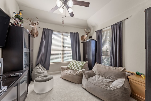 sitting room featuring vaulted ceiling, carpet flooring, a ceiling fan, and baseboards