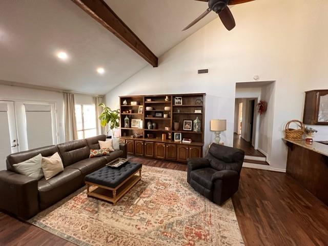 living room featuring visible vents, ceiling fan, beamed ceiling, wood finished floors, and high vaulted ceiling