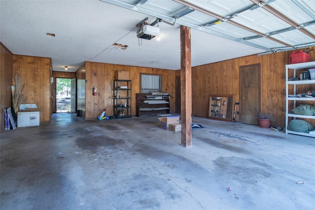 garage featuring wood walls and a garage door opener