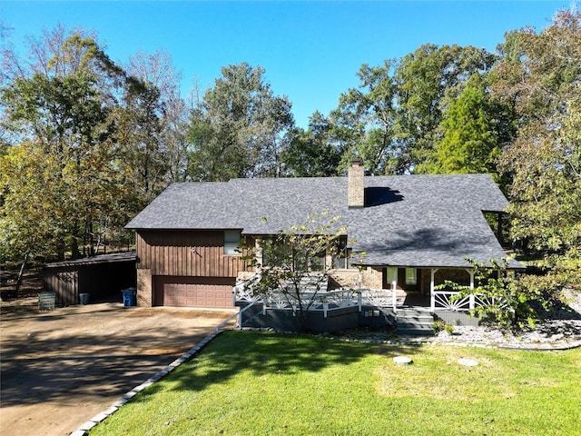 view of front of property with a front yard, roof with shingles, driveway, and a chimney