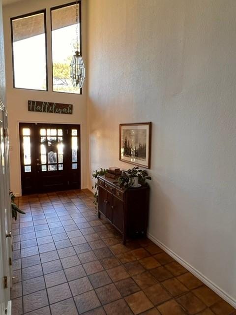 foyer featuring a towering ceiling and baseboards