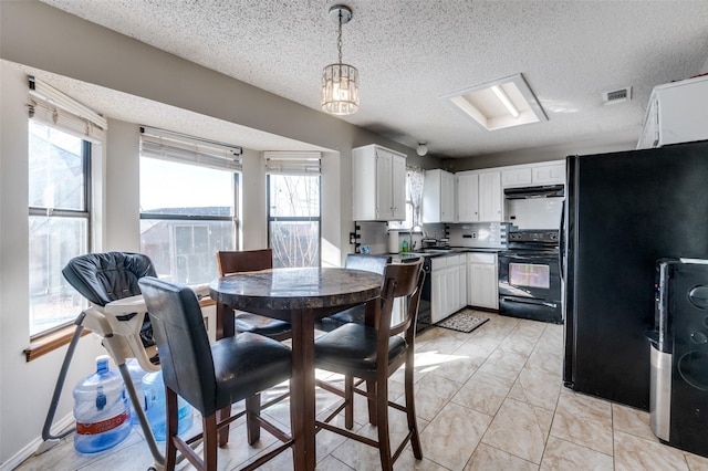 dining space featuring visible vents, a textured ceiling, and baseboards