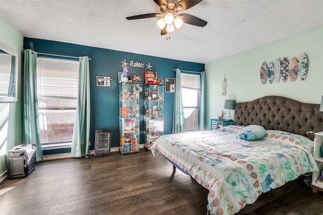 bedroom with a ceiling fan, a textured ceiling, baseboards, and wood finished floors