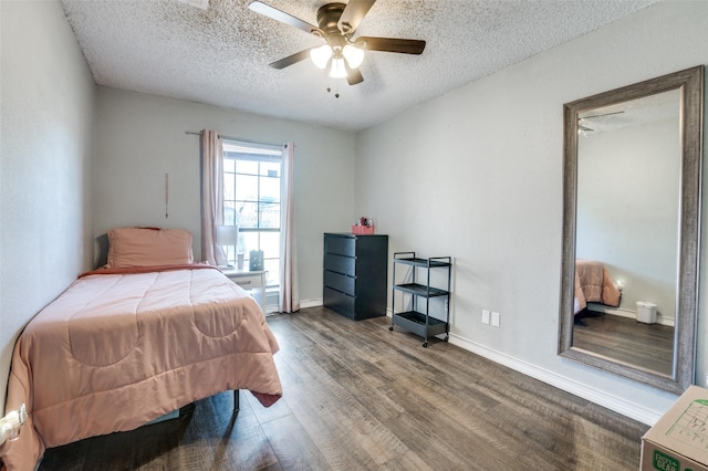 bedroom featuring a ceiling fan, a textured ceiling, baseboards, and wood finished floors