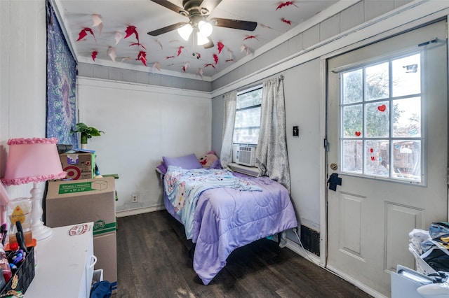 bedroom with ceiling fan, cooling unit, wood finished floors, and baseboards