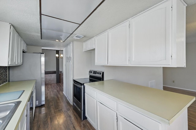 kitchen with dark wood-style floors, stainless steel appliances, light countertops, visible vents, and white cabinetry