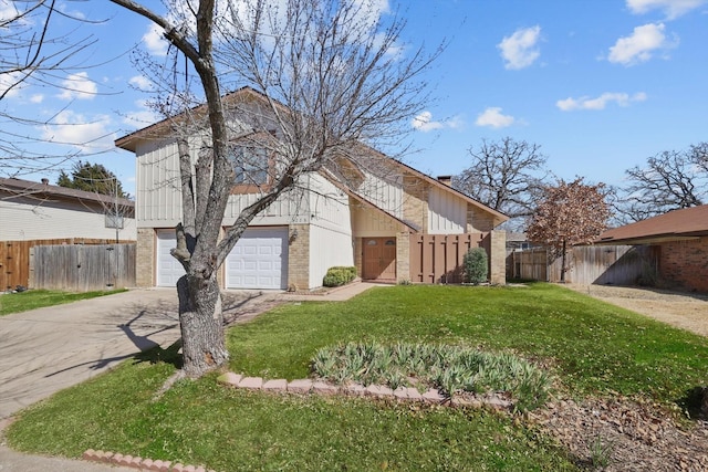 view of front facade featuring a front yard, concrete driveway, brick siding, and fence