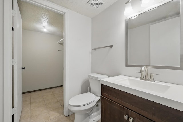 bathroom with baseboards, visible vents, toilet, a textured ceiling, and vanity