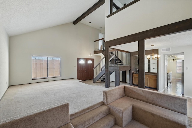 sunken living room featuring a notable chandelier, visible vents, carpet flooring, beamed ceiling, and stairs