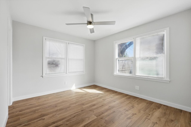empty room featuring a ceiling fan, baseboards, and wood finished floors