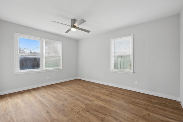 spare room featuring wood finished floors, baseboards, and ceiling fan