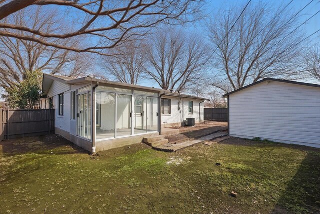 rear view of house featuring a yard, a sunroom, central AC, and fence