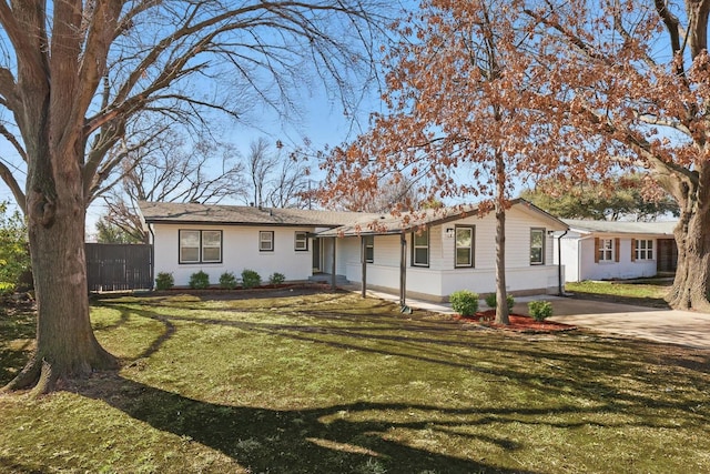 ranch-style home featuring fence and a front lawn