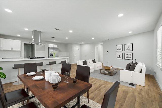 dining space with baseboards, visible vents, light wood-style floors, and recessed lighting