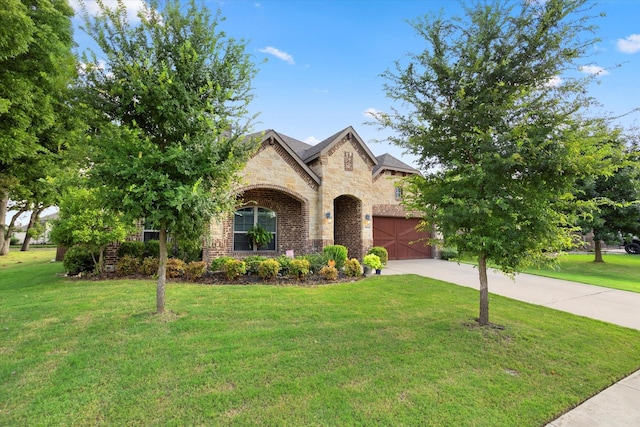 french country inspired facade featuring a garage, concrete driveway, and a front lawn