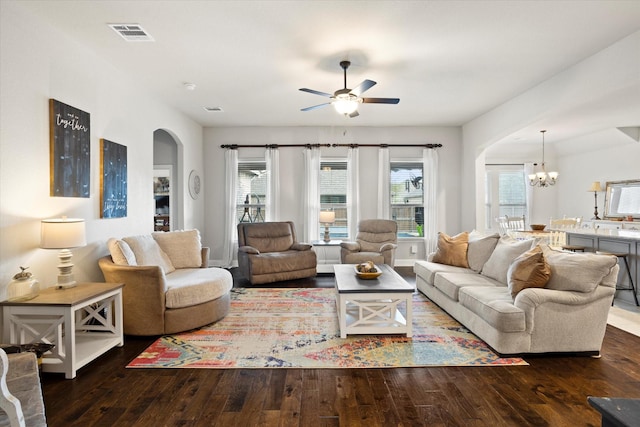 living room featuring arched walkways, visible vents, plenty of natural light, and hardwood / wood-style floors