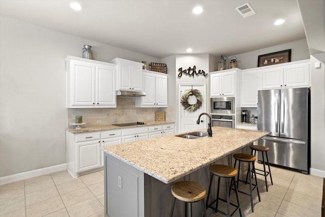 kitchen featuring stainless steel appliances, backsplash, light tile patterned flooring, a sink, and under cabinet range hood