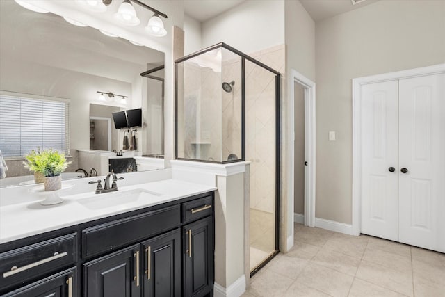 bathroom featuring a shower stall, vanity, baseboards, and tile patterned floors