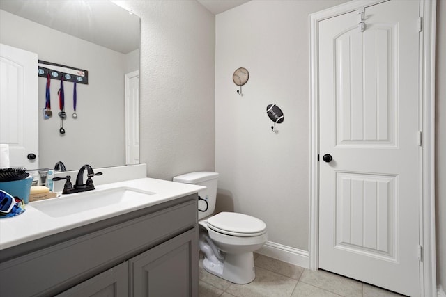 half bath with toilet, tile patterned flooring, and vanity