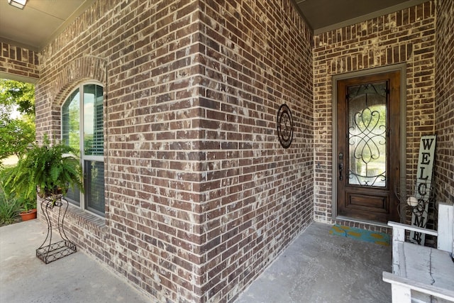 entrance to property featuring brick siding