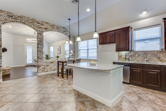 kitchen with dishwasher, brick wall, arched walkways, and a sink