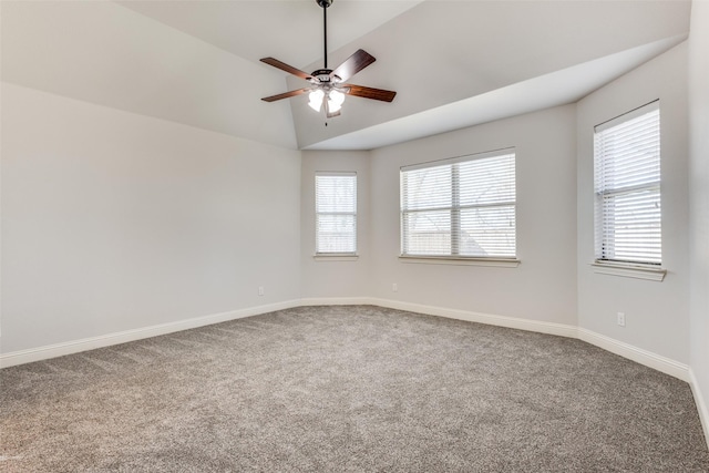 carpeted empty room featuring ceiling fan, baseboards, and vaulted ceiling