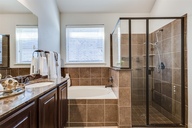 full bathroom featuring a stall shower, a garden tub, and vanity