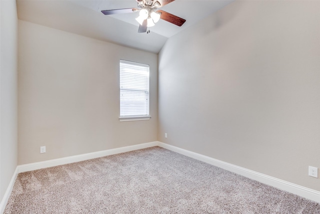 carpeted spare room with ceiling fan, baseboards, and vaulted ceiling