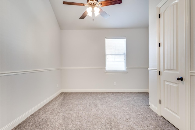 carpeted spare room with a ceiling fan and baseboards