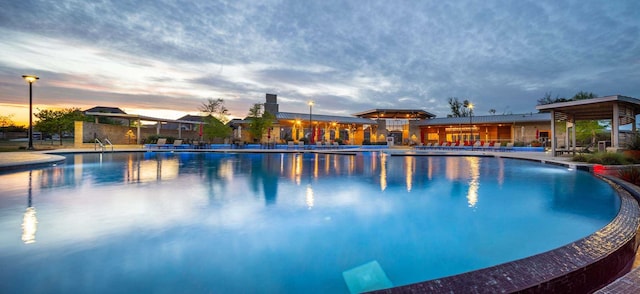 pool at dusk with a community pool