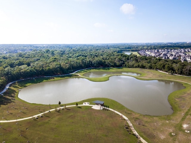 drone / aerial view featuring a water view and a wooded view