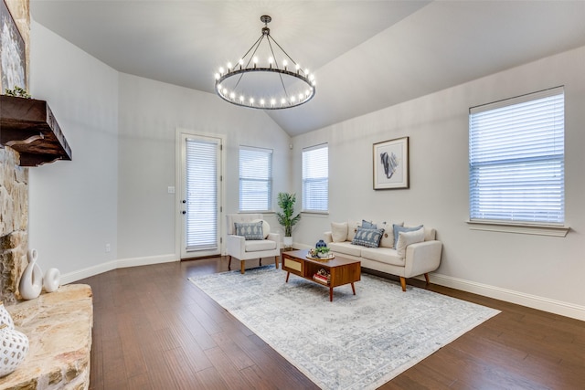 living room with a chandelier, lofted ceiling, dark wood-style flooring, and baseboards