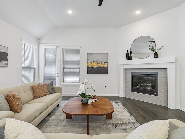 living area with recessed lighting, a fireplace, wood finished floors, baseboards, and vaulted ceiling