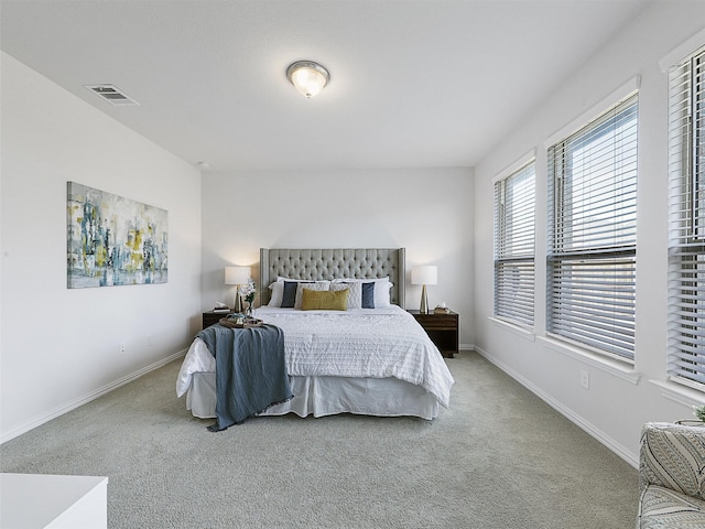 bedroom with light colored carpet, visible vents, and baseboards