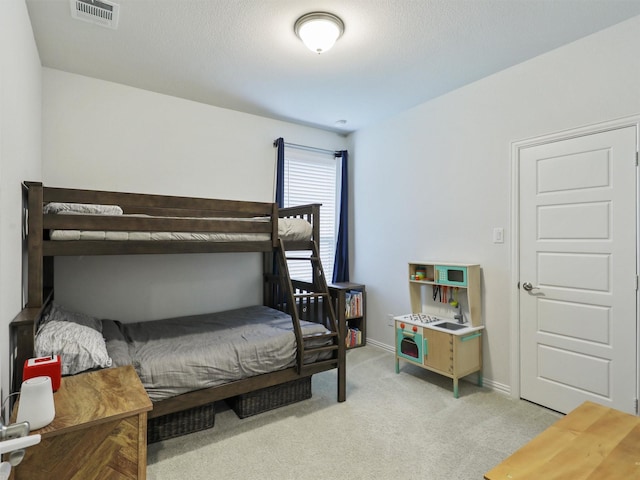 bedroom featuring baseboards, visible vents, and light colored carpet