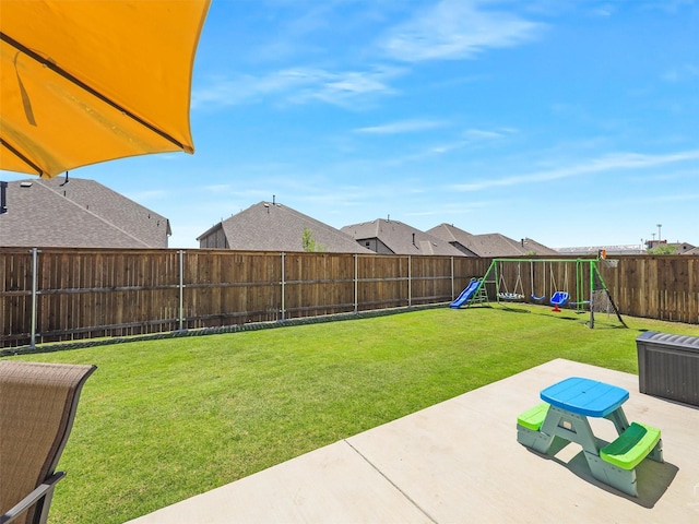 view of yard featuring a playground, a patio area, and a fenced backyard