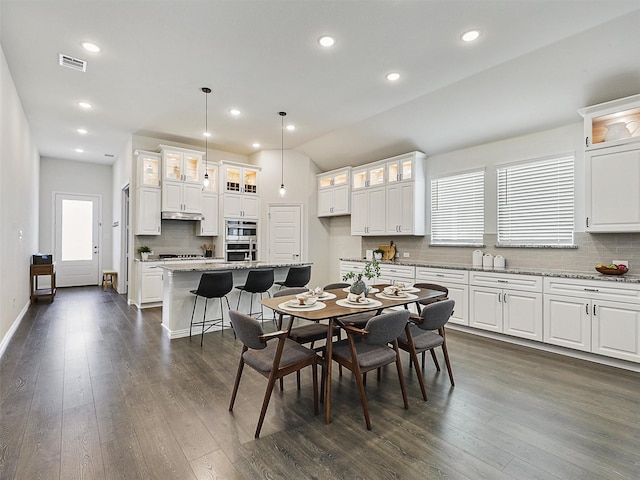 dining space featuring dark wood-style flooring, visible vents, and plenty of natural light