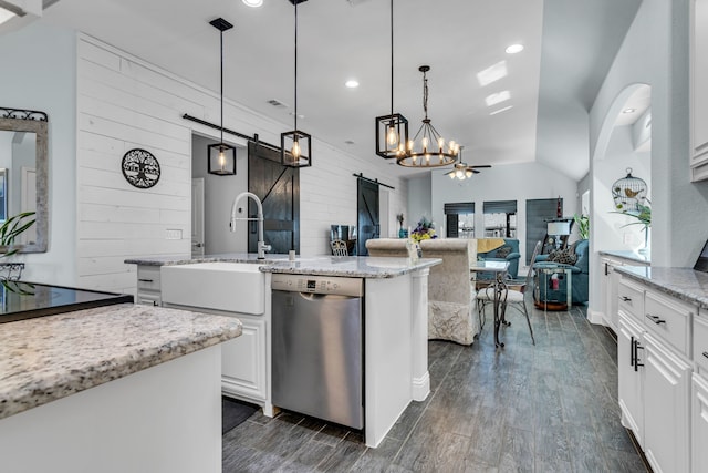 kitchen featuring light stone counters, a barn door, dark wood-type flooring, white cabinetry, and stainless steel dishwasher