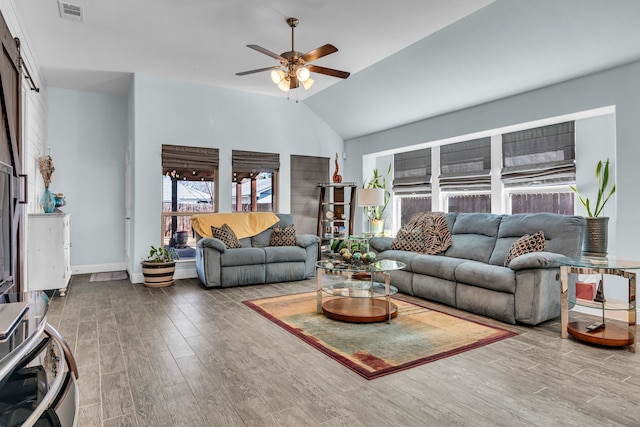 living area with baseboards, visible vents, a ceiling fan, lofted ceiling, and wood finished floors