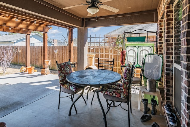 view of patio / terrace with outdoor dining area, fence, and a ceiling fan