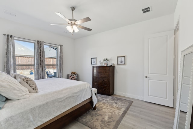 bedroom featuring ceiling fan, light wood-type flooring, visible vents, and baseboards