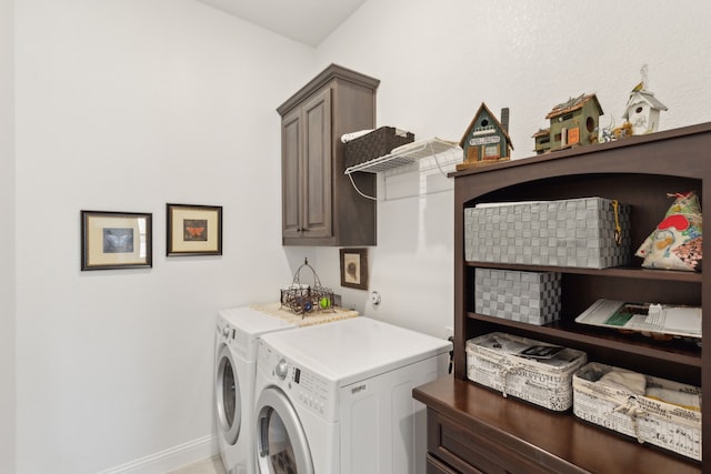 clothes washing area with separate washer and dryer, cabinet space, and baseboards