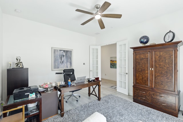 home office featuring light wood finished floors, french doors, and a ceiling fan