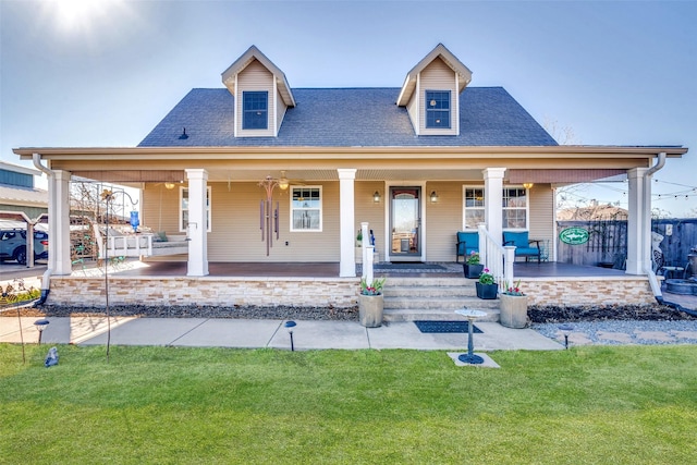 view of front of home with a shingled roof, covered porch, and a front lawn