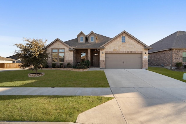 view of front of house with a shingled roof, an attached garage, stone siding, driveway, and a front lawn