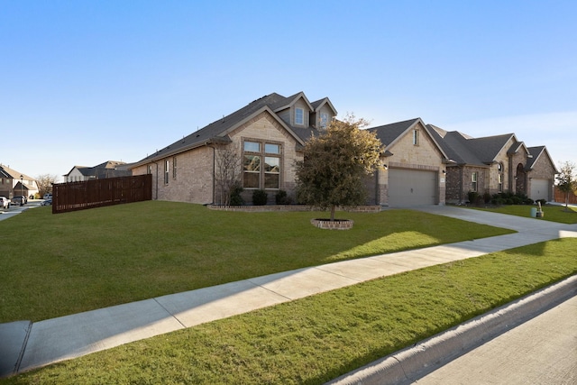 view of front of property with driveway, a garage, fence, a front yard, and brick siding