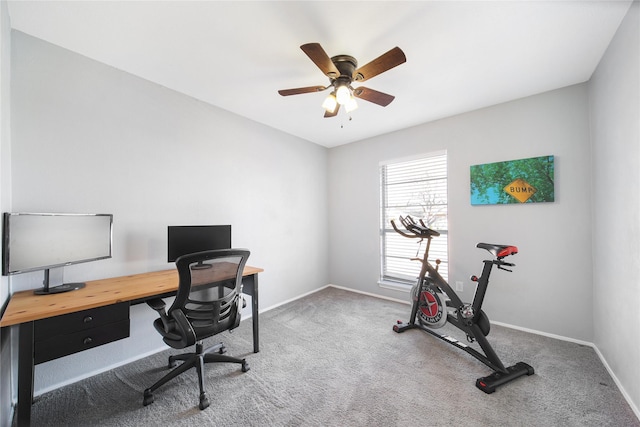 carpeted home office with ceiling fan and baseboards