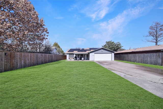 view of front of home featuring solar panels, aphalt driveway, a front lawn, and a fenced backyard