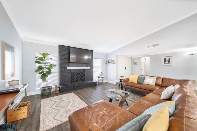 living area with crown molding, a brick fireplace, visible vents, and vaulted ceiling