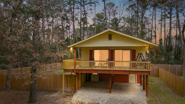 back of house featuring a carport, fence private yard, and driveway